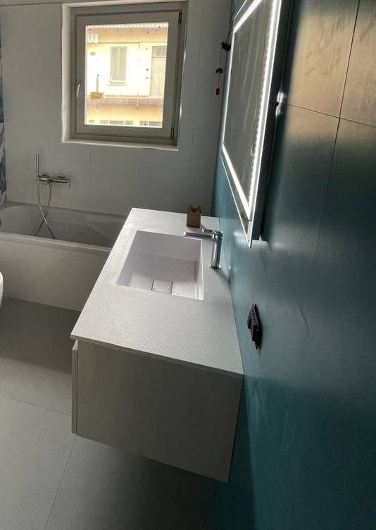 Dopo: il bagno finito, con la vasca sotto la finestra e il mobile lavabo con lo specchio